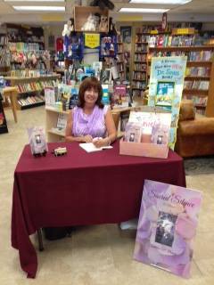 Woman author doing a book signing for her book called Sacred Silence